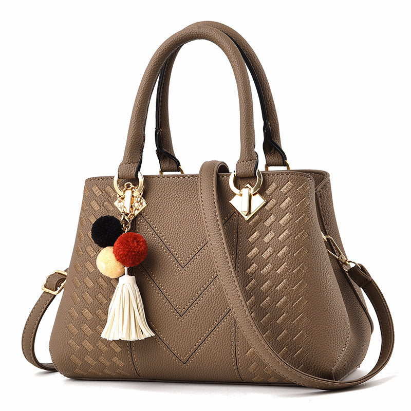 Trendy brown luxury handbag for women with a fashionable design, gold hardware, and playful decoration.