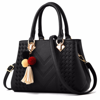 Elegant black luxury handbag for women with a stylish design, gold detailing, and colorful tassel accessory.