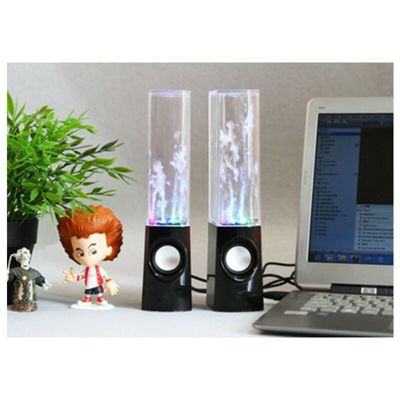 Dancing water speakers in black, with colorful lights, positioned beside a laptop and a small plant, showcasing a fun party vibe.