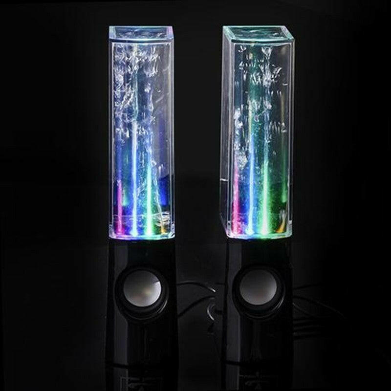 Illuminated black dancing water speakers with vibrant colors in a dark setting, enhancing the audio experience.