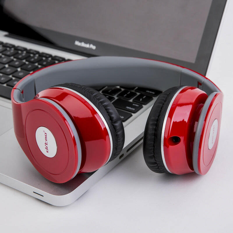 Vibrant red wired gaming headphones placed on a laptop keyboard, featuring plush ear cushions.