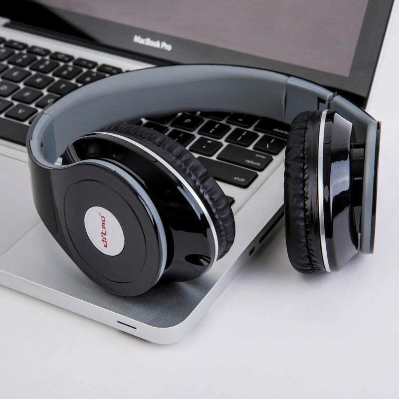 Shiny black wired gaming headphones on a MacBook Pro, showcasing sleek design and comfort.