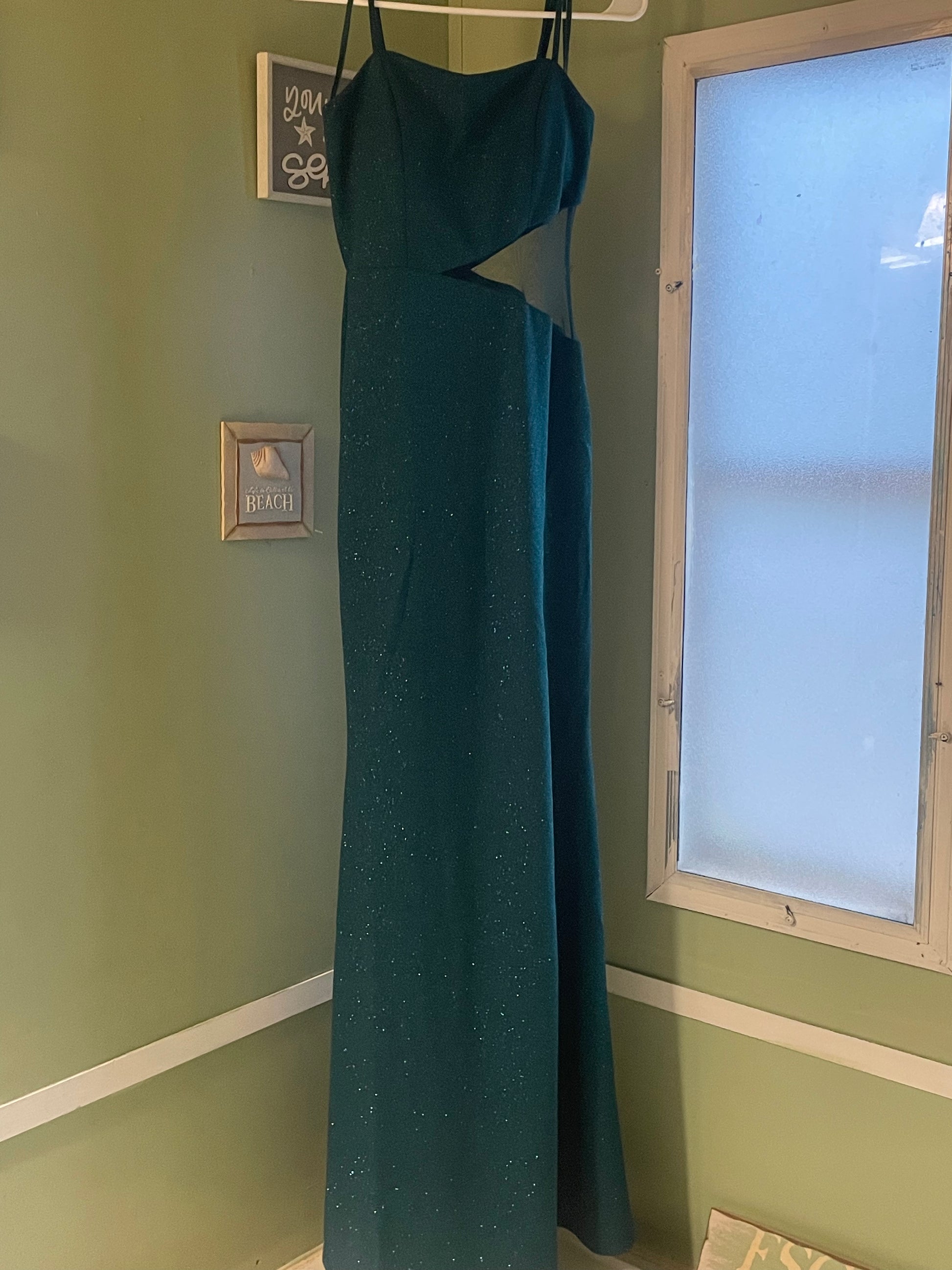 Another angle of the elegant green dress, emphasizing its long, sleek design and shimmering sequins.