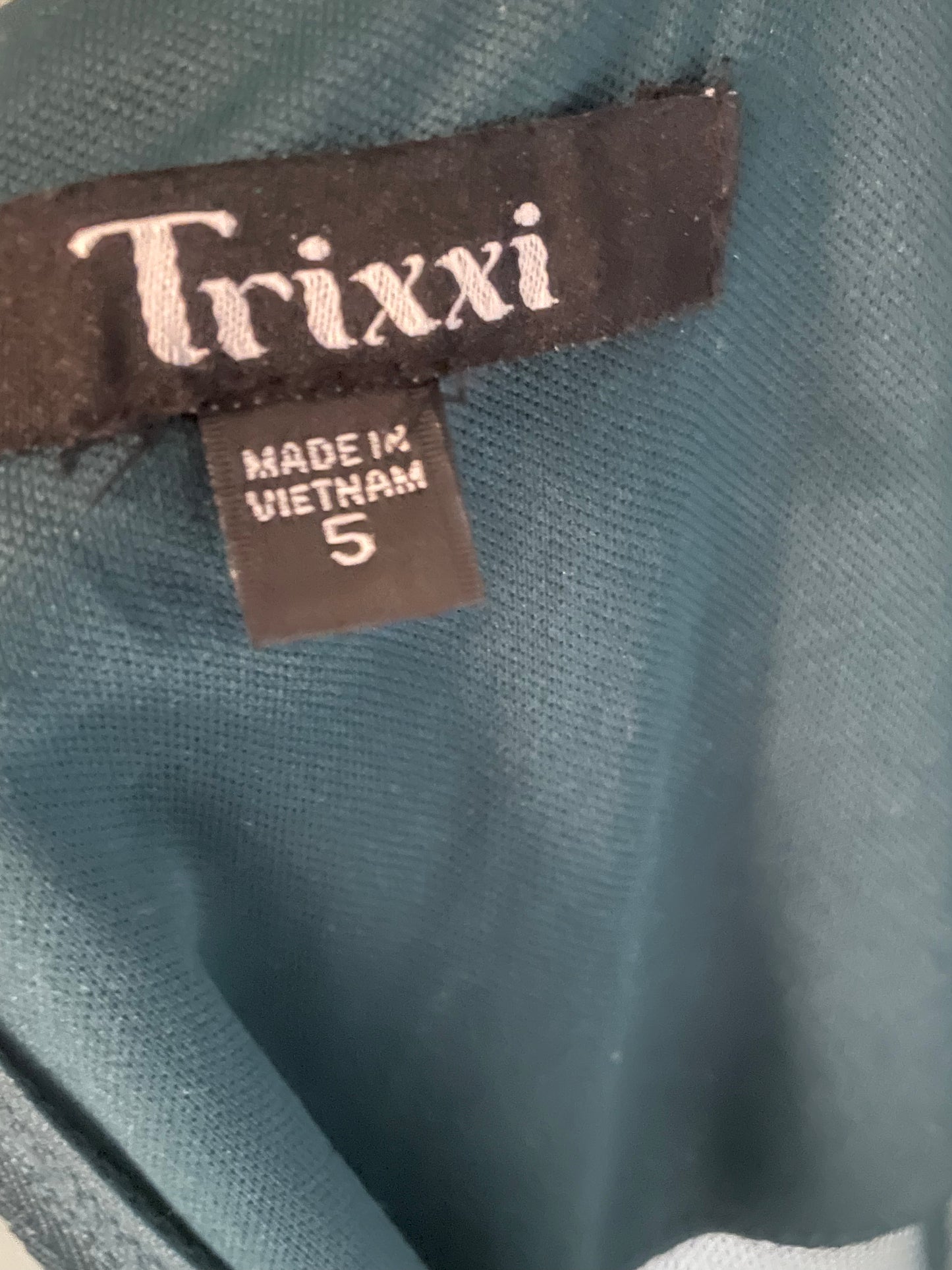 Label of the elegant green dress, displaying the brand name Trixxi and size information.