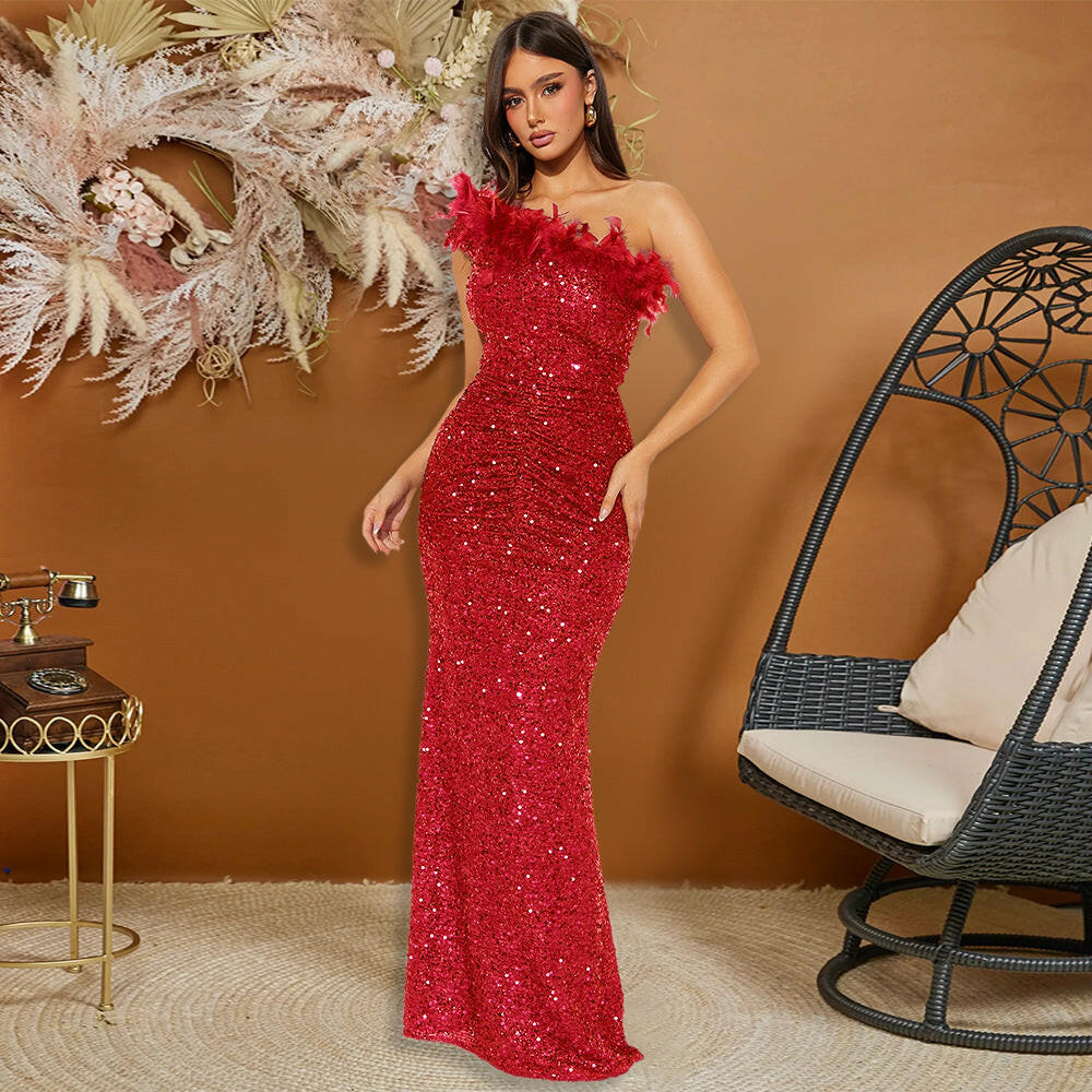 A model dressed in a vibrant red sequin evening dress with feather detailing, striking a pose in a chic indoor setting.